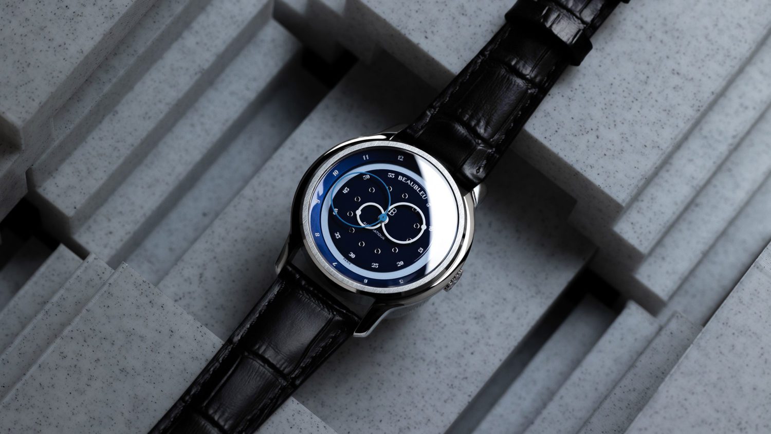 <p class="p1">La montre Vitruve GMT Blue possède deux couronnes cachées. En activant l'une des couronnes cachées, le réhaut, frappé de 12 chiffres romains, tourne et indique l'heure d’une autre partie du monde.</p>