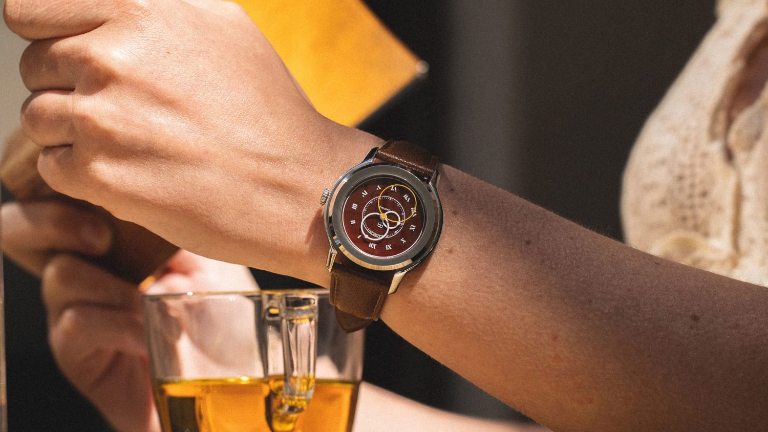 <p class="p1">The Vitruve Origine Cognac watch possess a sandwich dial. The three round hands turn on a first smoked dial, pad printed with Roman numerals, and resting on the second somber cognac guilloche dial.</p>