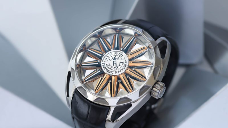 Inspired by the ancient world, the great explorers, and the astronomical instruments they invented… Frederic Jouvenot collections are all about invention, innovative concepts, with a spice of poetry and artistic sensitivity.
Result of a 2-year R&D and several patents, the unique 24-hour jumping-cage complication mechanism is enclosed in a central 12 mm capsule which contains no fewer than 100 parts, including 24 rubies which will activate the hour’s jumping beams.
A micro-mechanics work of art.

