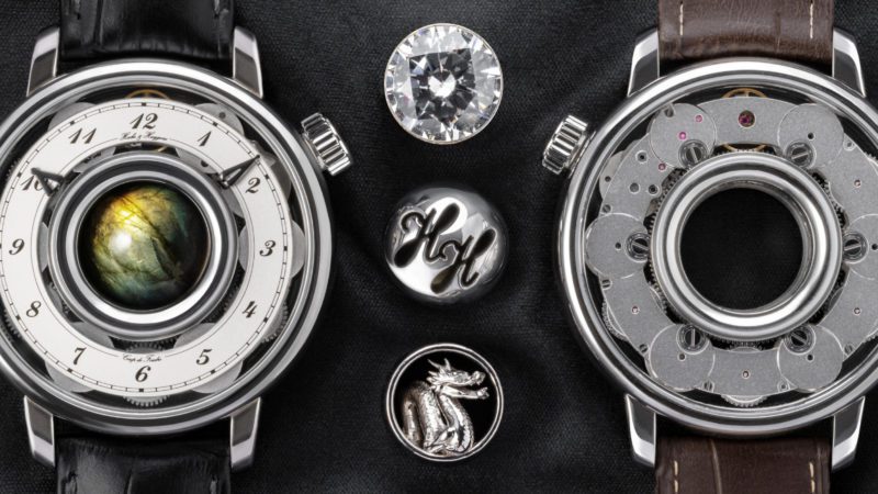 Hooke & Huygens est une nouvelle marque de montres mécaniques de luxe suisses avec des joyaux personnels qui sont facilement échangés dans le centre de la montre annulaire avec huit barillets. Les gemmes sont personnalisées pour chaque montre, soit de billes de pierres naturelles de 15 mm soit de billes de métal, soit sculptures ou pierres précieuses dans un cadre.
Le mouvement annulaire semi-squelette breveté dispose de 8 barillets à remontage manuel élégamment connectés, offrant une réserve de marche de près d'une semaine.
Les prix commencent à CHF 26'400 pour le boîtier en acier CHF 42'800 pour or.