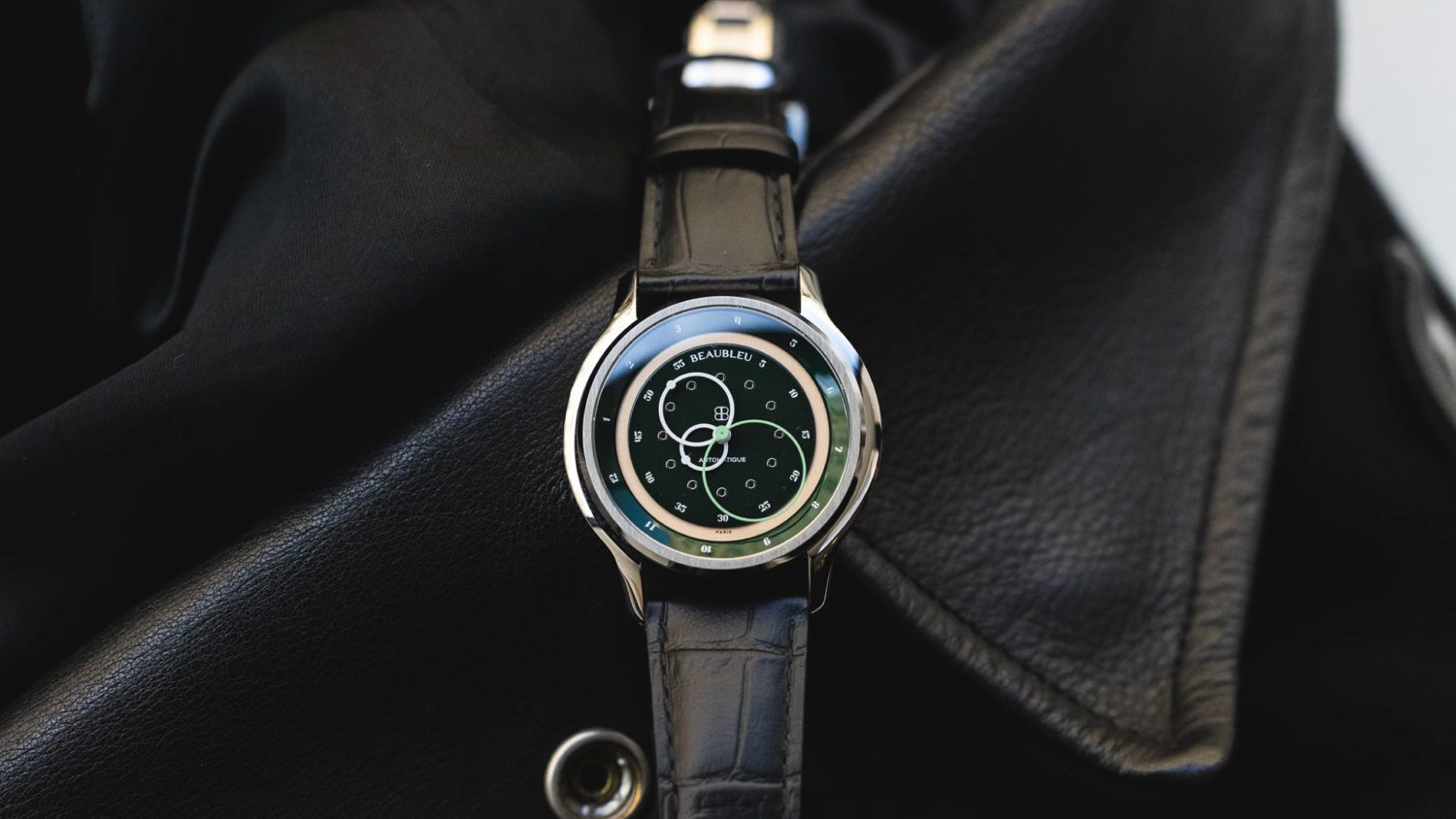 Avec son cadran laqué d'un profond vert anglais, et son réhaut tournant, la montre Vitruve GMT Vert affiche le temps d'ici et d'ailleurs. Elle indique en son centre l'heure locale et à l'extérieur du cadran l'heure d'une autre partie du monde.